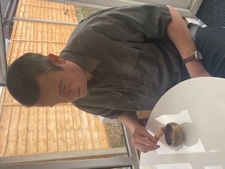 Photo of Martin striking singing bowl.