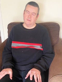 Photo of Martin sitting in chair meditating.